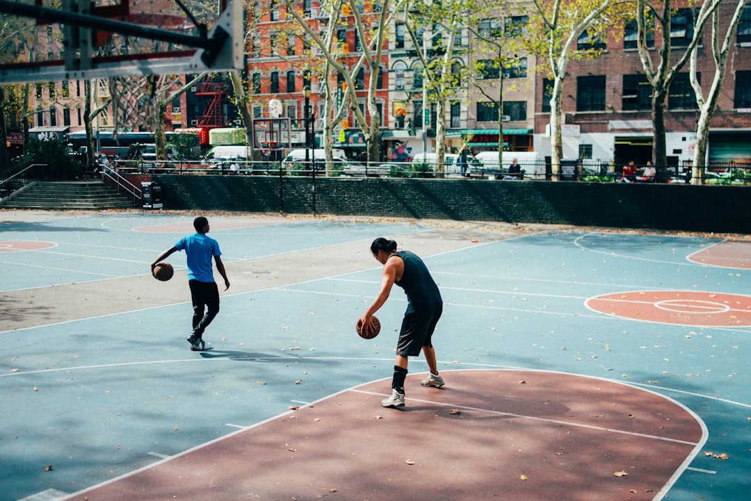 man in black shirt and black pants playing basketball during daytime