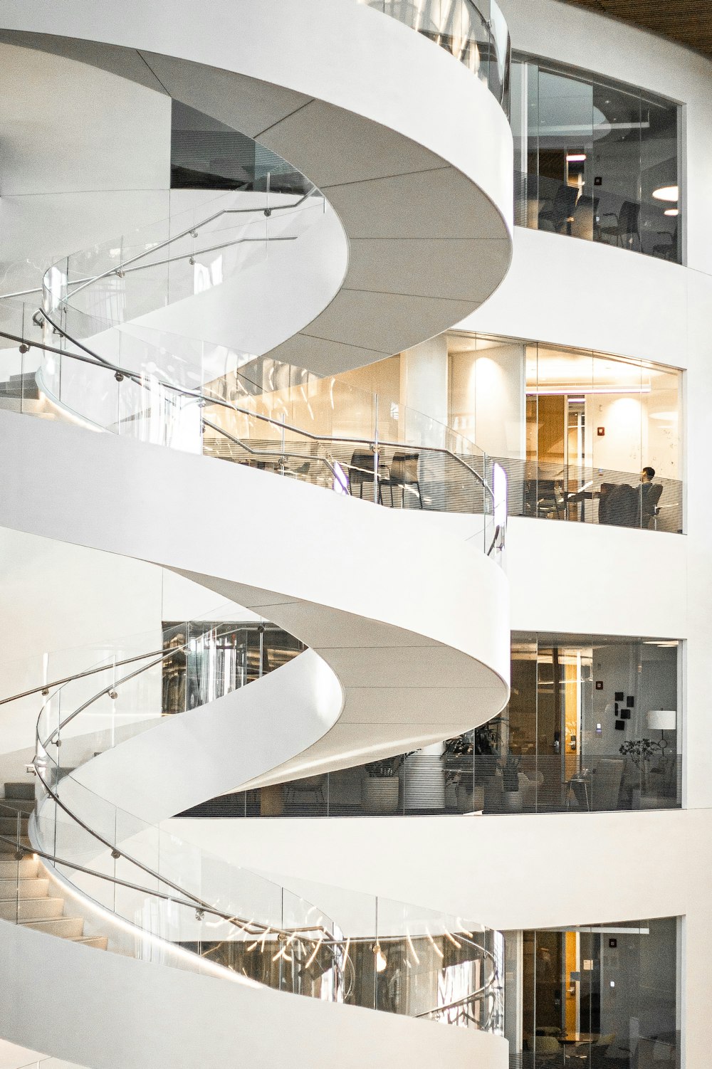 Escalera de caracol blanca con ventanas de cristal