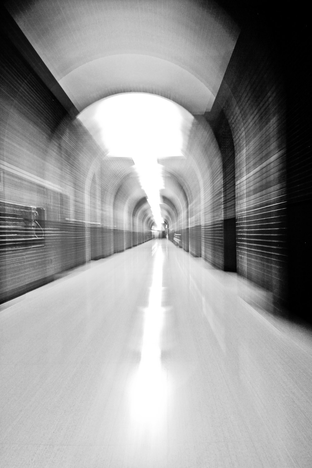grayscale photo of tunnel with light