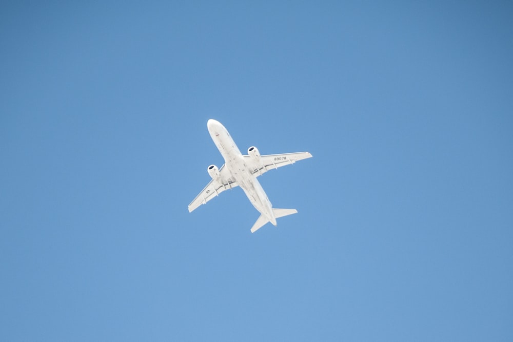 낮 동안 공중에 떠 있는 하얀 비행기