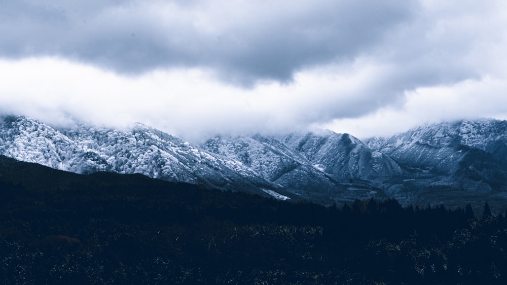 snow covered mountain under cloudy sky during daytime