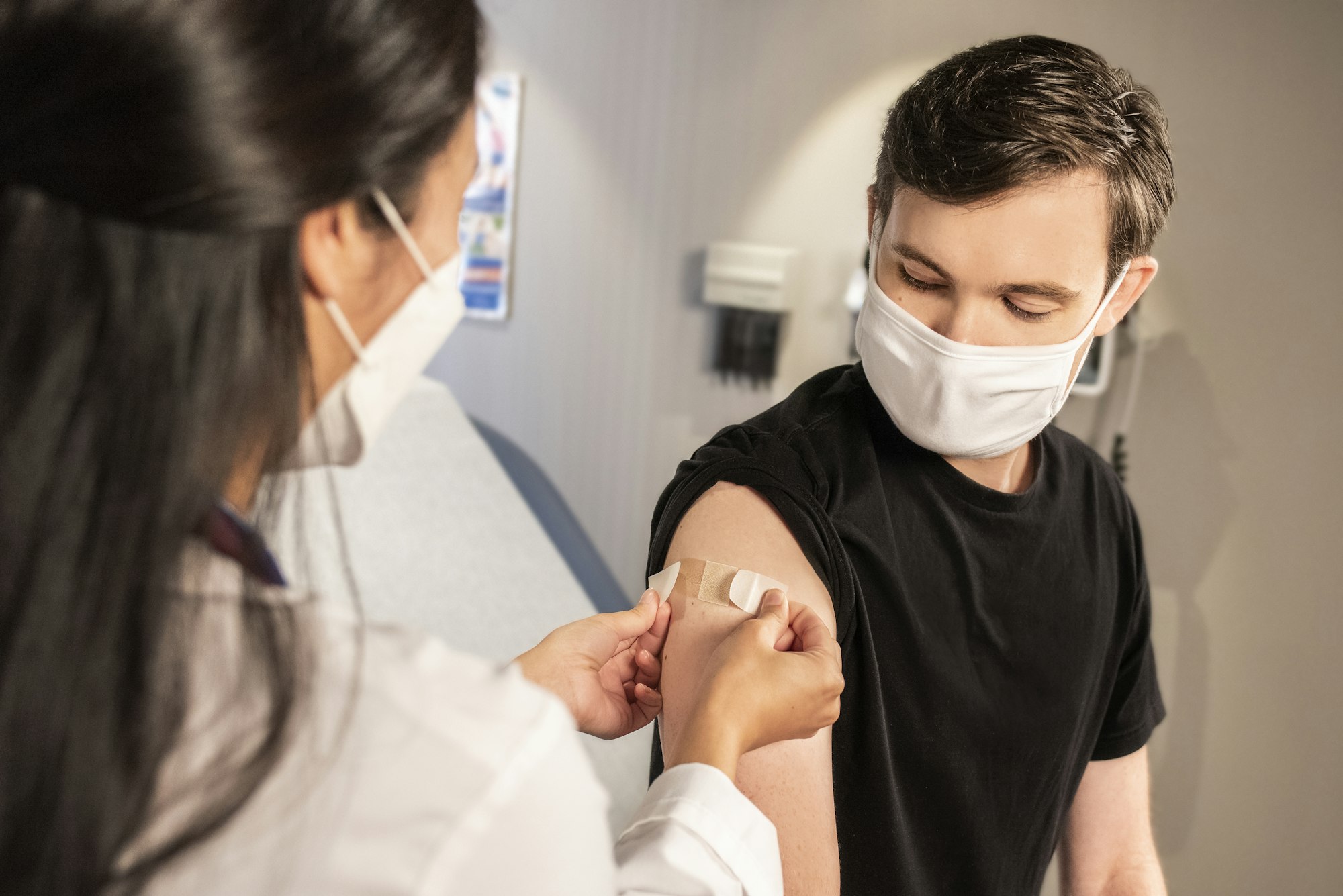 In this 2020 photograph, captured inside a clinical setting, a health care provider places a bandage on the injection site of a patient, who just received an influenza vaccine. The best way to prevent seasonal flu, is to get vaccinated every year. Centers for Disease Control and Prevention (CDC) recommends everyone 6-months of age and older get a flu vaccine every season.