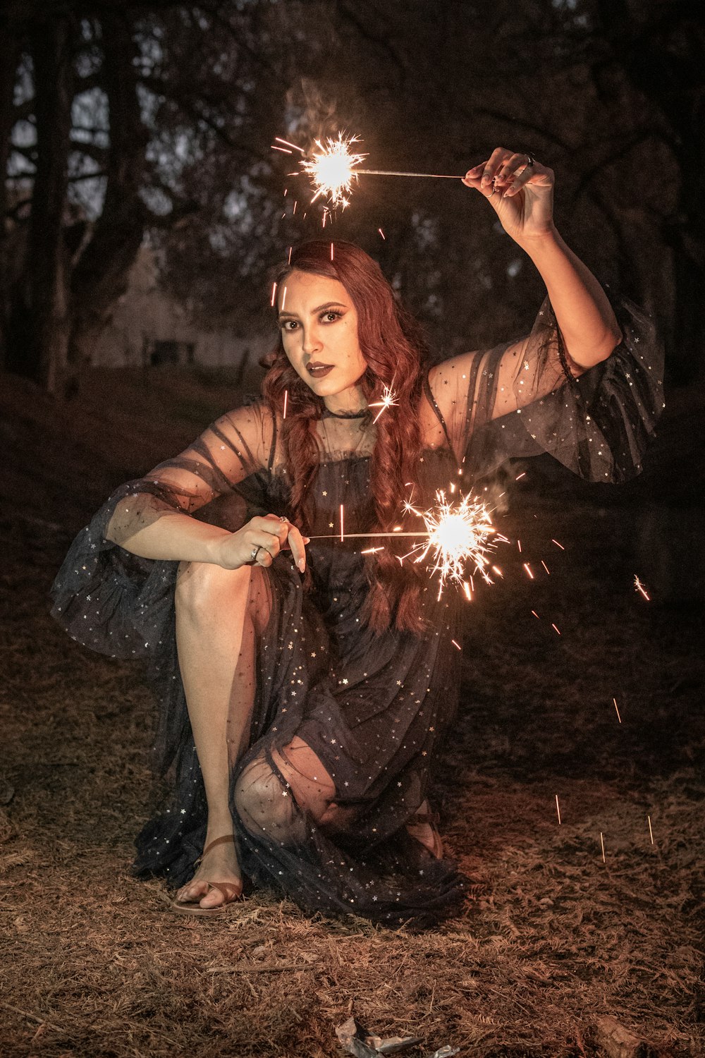 woman in black dress holding sparkler