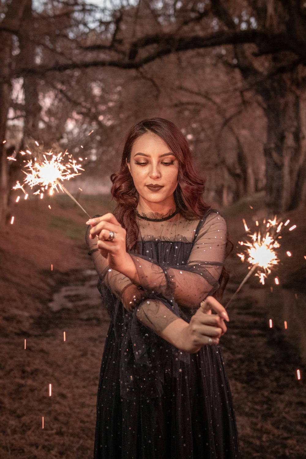 woman in black dress holding white dandelion flower