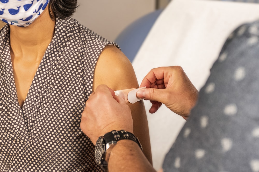 mulher na camisa de bolinhas preta e branca que segura o tubo de plástico branco