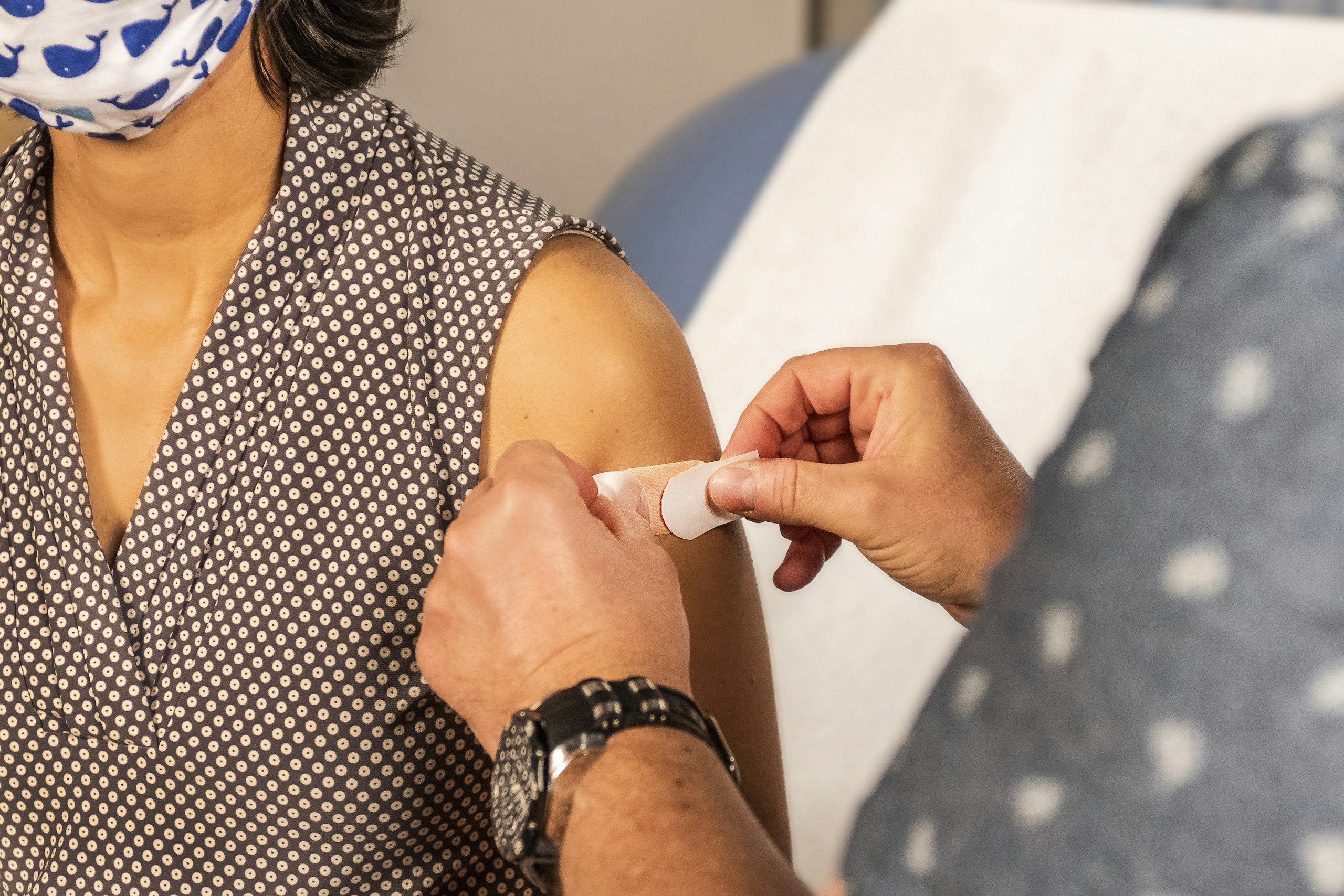 vacuna del coronavirus, woman in black and white polka dot shirt holding white plastic tube