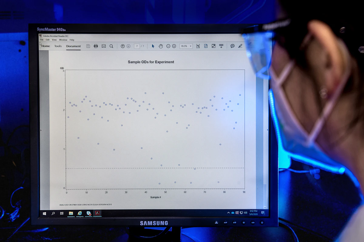 Researcher analyzing cancer data with artificial intelligence on screen