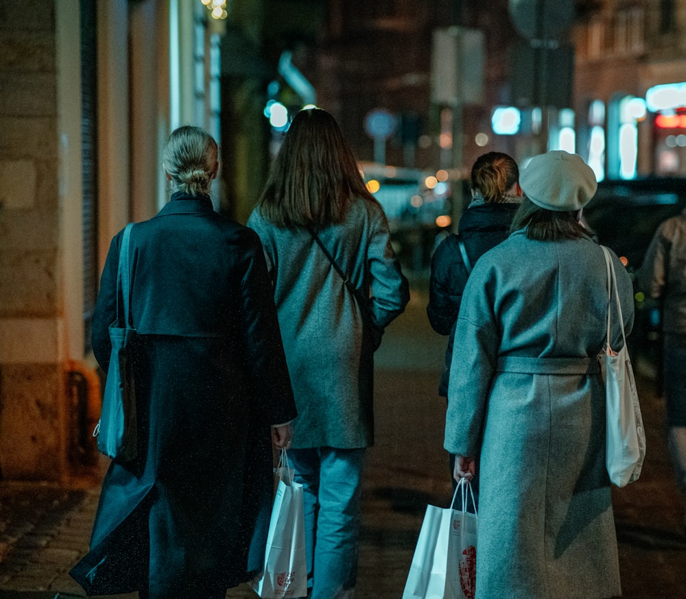 man and woman walking on sidewalk during night time