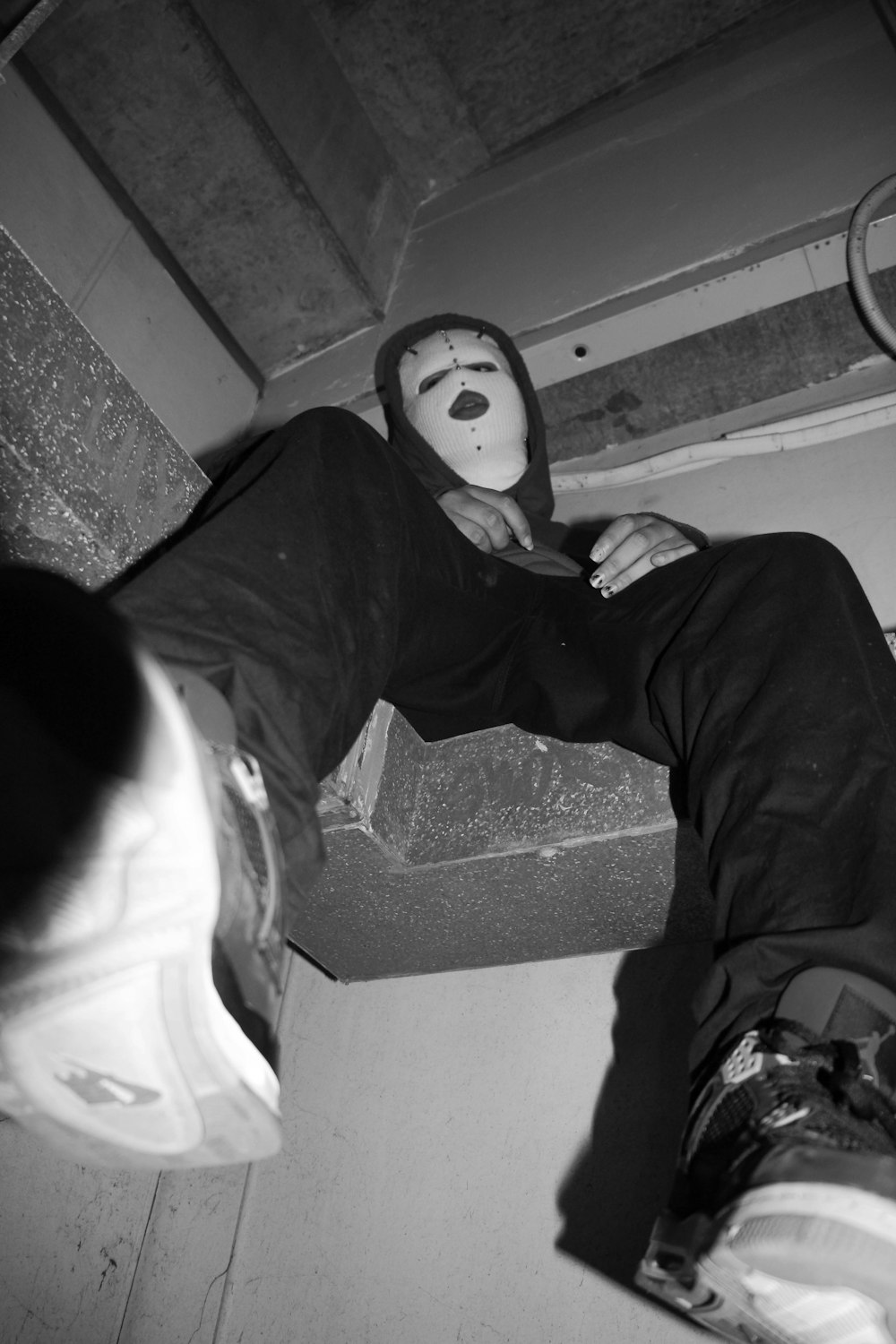 man in black jacket and pants sitting on concrete stairs