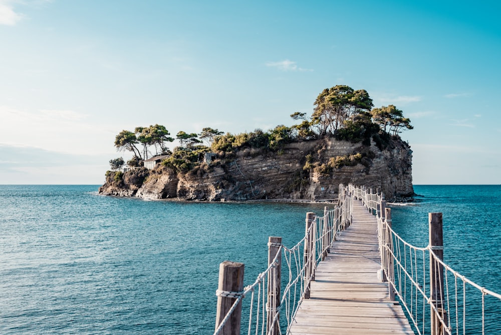 ponte de madeira marrom sobre o mar azul sob o céu azul durante o dia