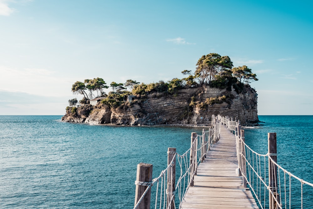 brown wooden bridge over blue sea under blue sky during daytime