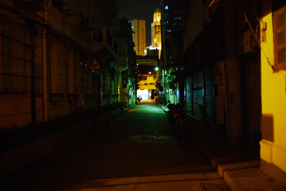 empty street in between buildings during night time