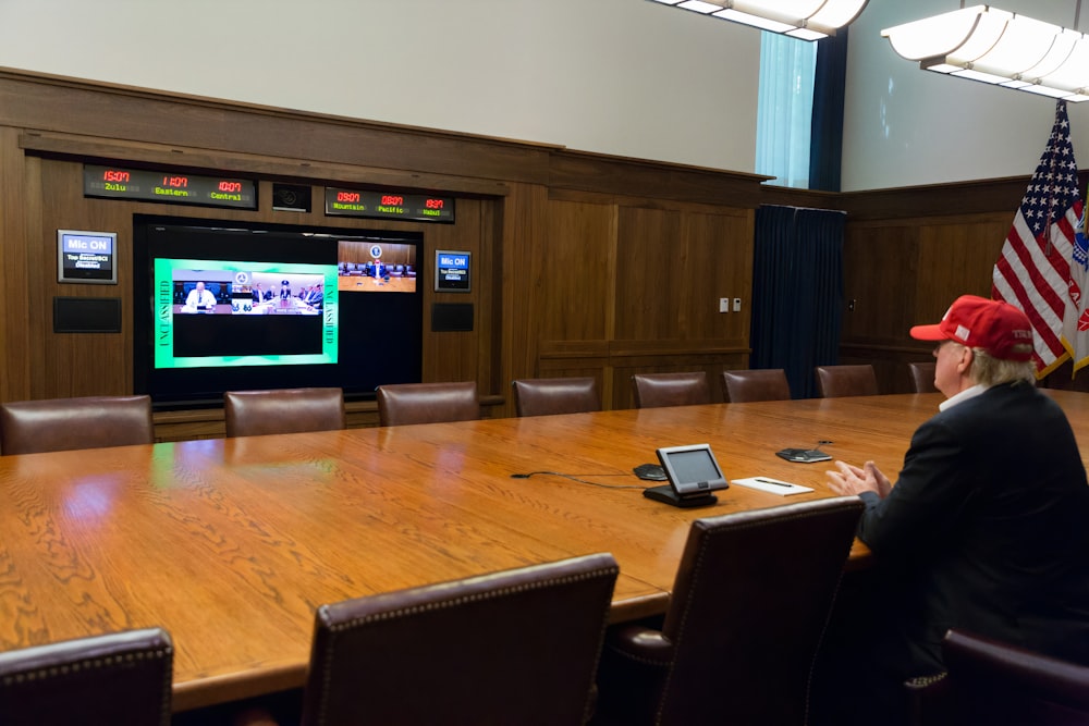 Televisor de pantalla plana negro encendido cerca de una pared de madera marrón