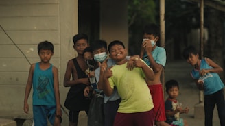 Smiling children wearing colorful casual clothes playing outdoors.
