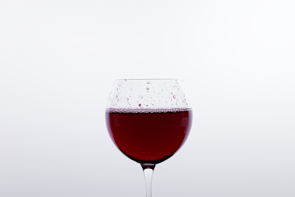 Copa de vino transparente con líquido tinto
