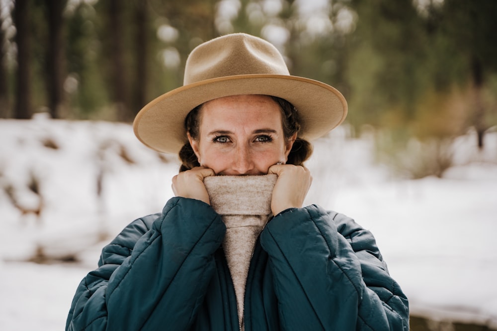 woman in blue jacket and brown hat