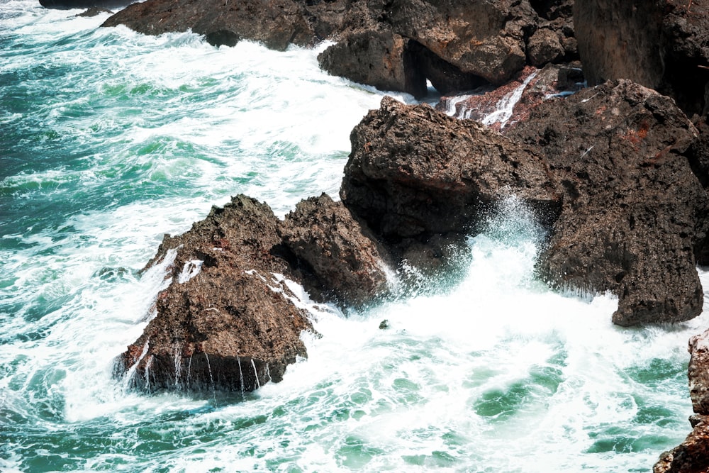 brown rock formation beside body of water during daytime