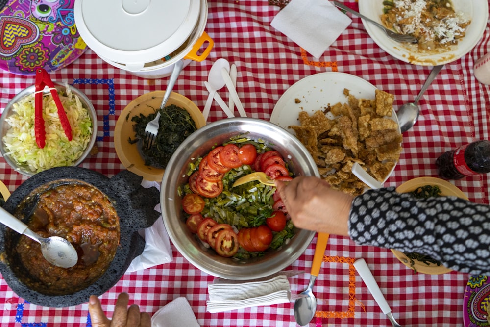 person holding stainless steel bowl with cooked food