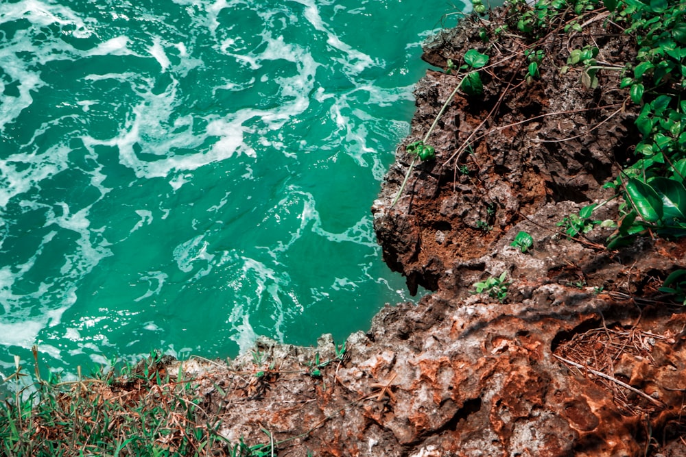 body of water near brown rock