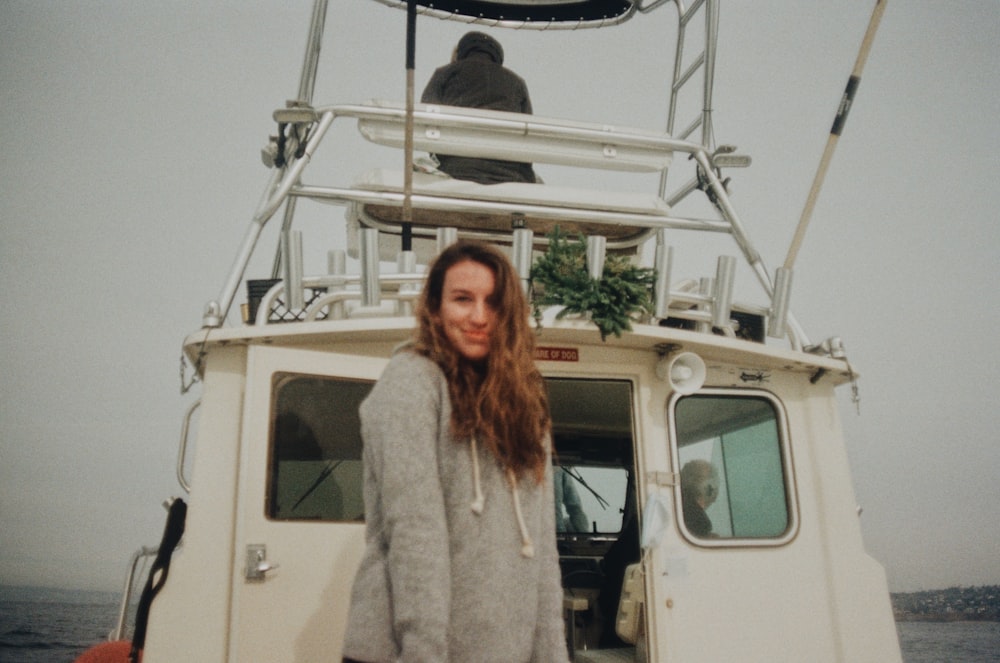 woman in white fur coat standing beside white van