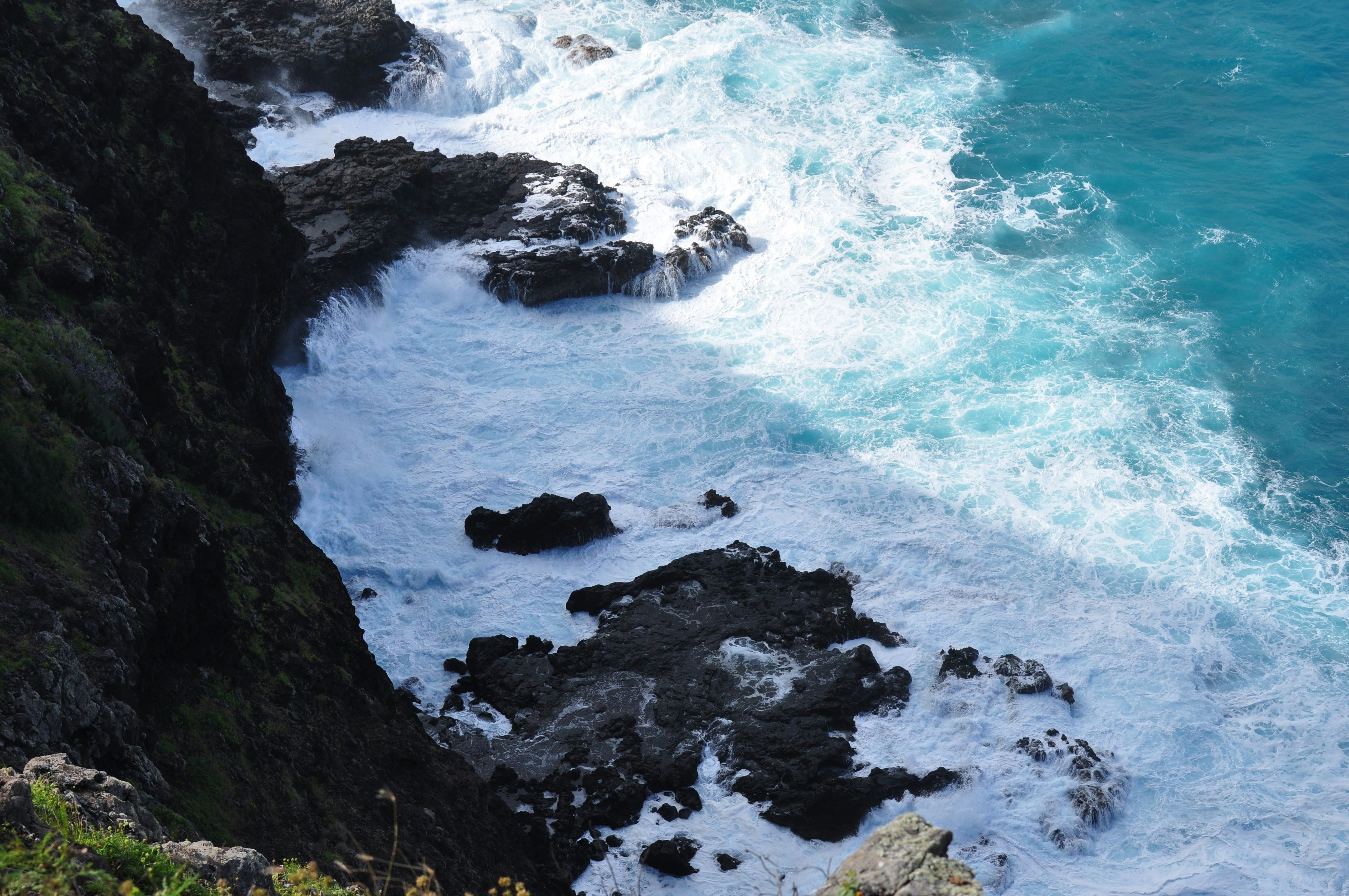 black rock formation beside blue sea during daytime