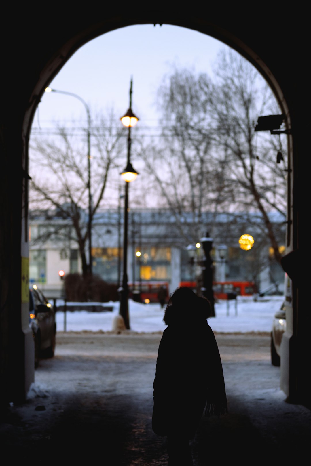 person in black hoodie standing on sidewalk during daytime