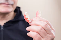 Flexible Valplast partial denture displayed on a clean white surface highlighting its translucency.