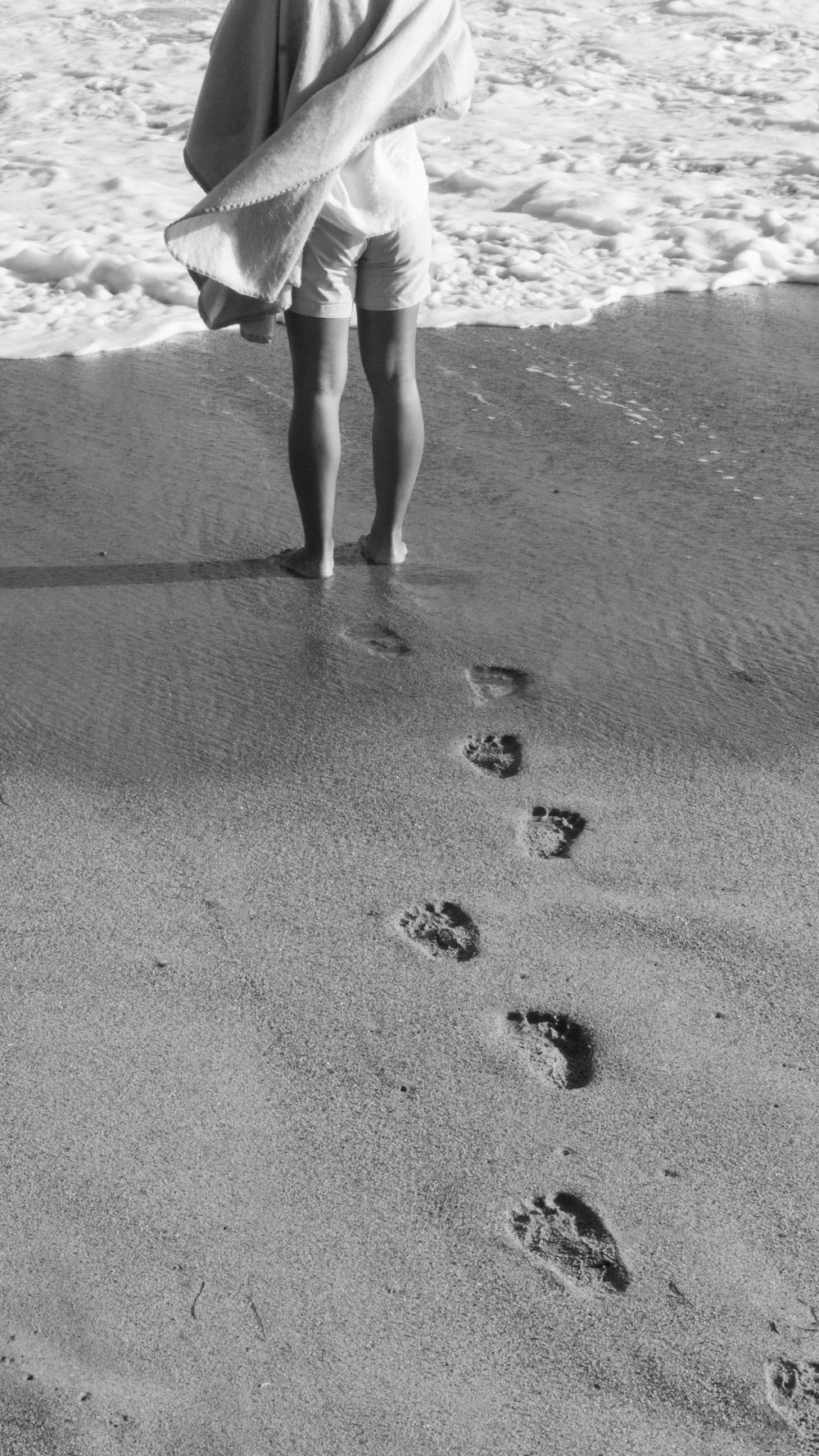 Frau, die tagsüber am Strand spazieren geht