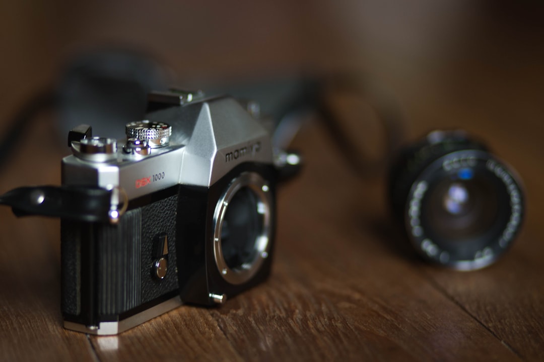 black and silver nikon dslr camera on brown wooden table