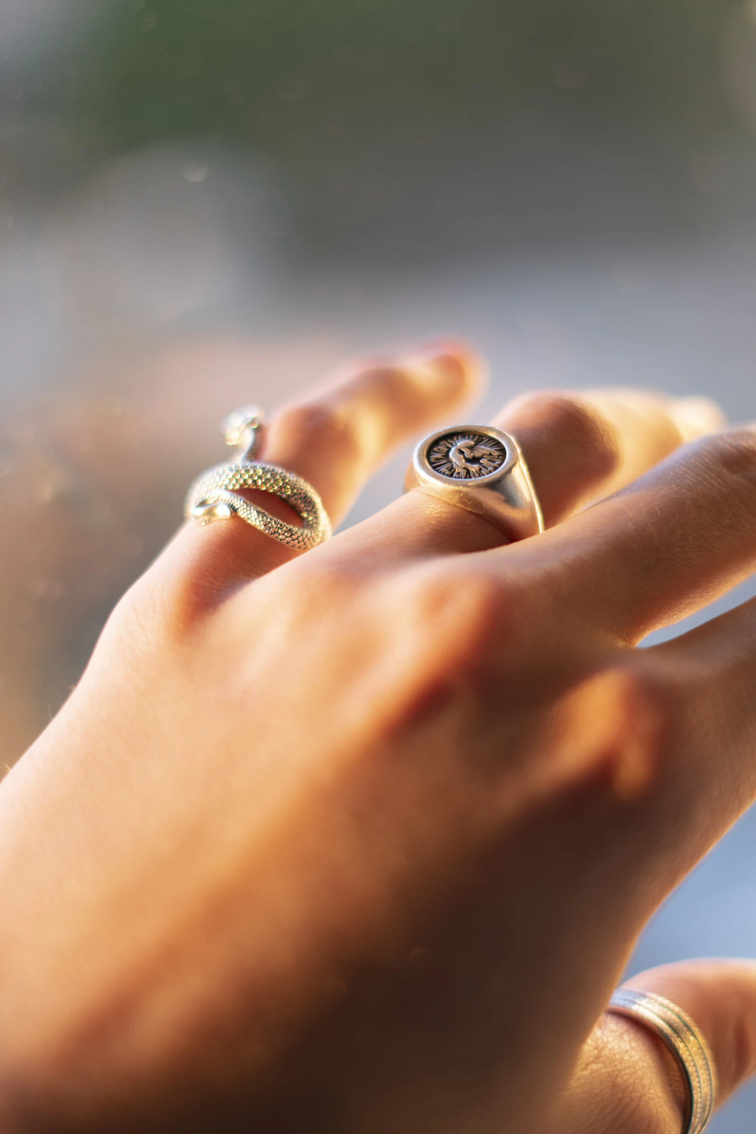 The Nodo signet ring in 18k gold worn on a little finger beside a second gold signet, in stock