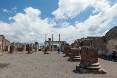 Tourists exploring ancient Zapotec ruins under a bright blue sky.