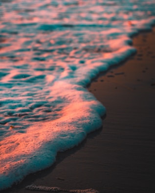 Gentle waves lapping at a serene beach at sunset.