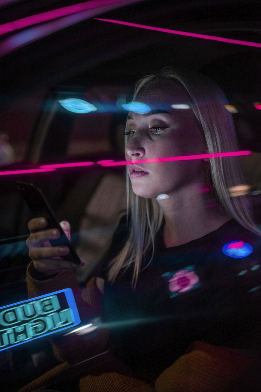 woman in black shirt holding smartphone