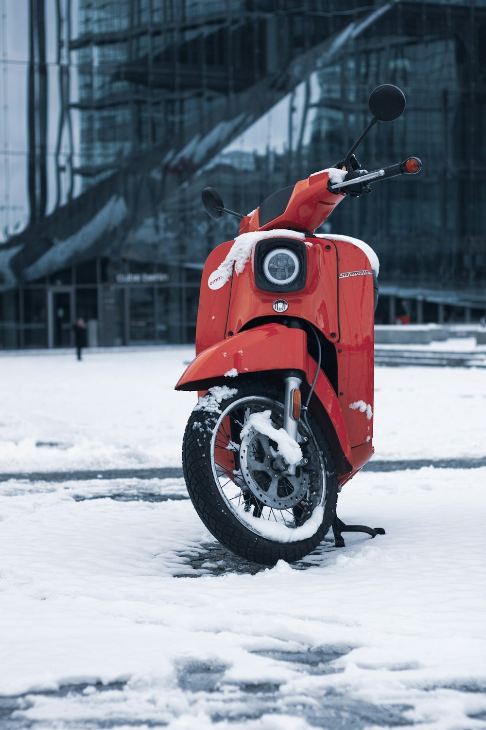 red and black motorcycle on snow covered ground during daytime