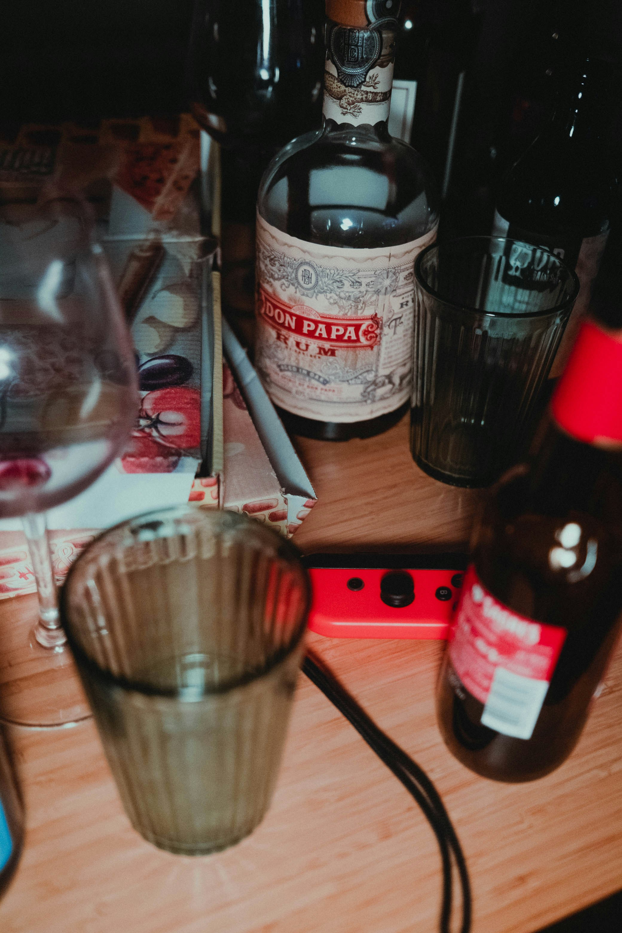 clear drinking glass beside bottle on table