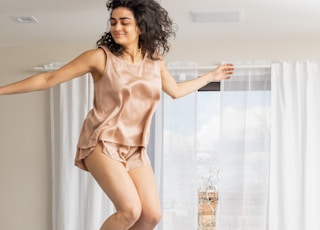 woman in brown lingerie kneeling on white bed