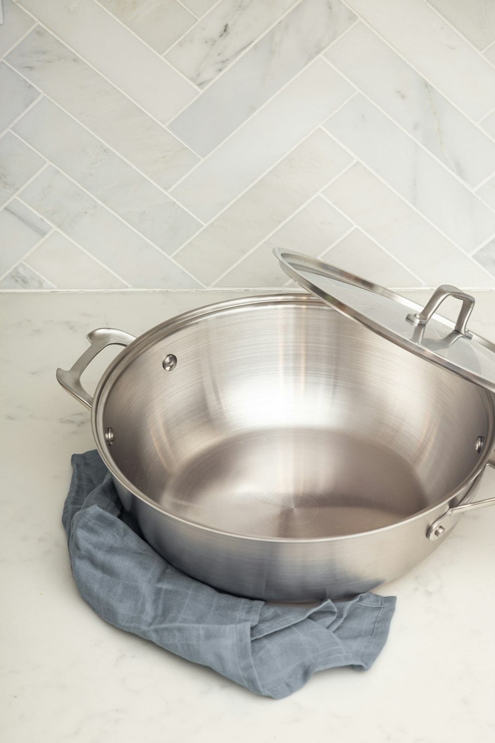 stainless steel cooking pot on blue denim jeans