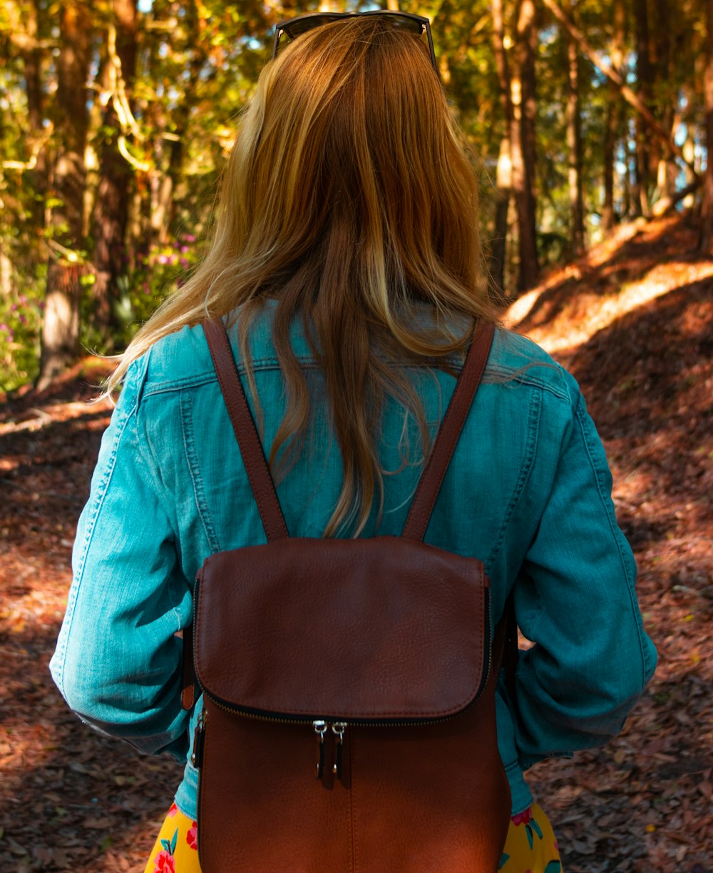woman in blue long sleeve shirt with black sling bag