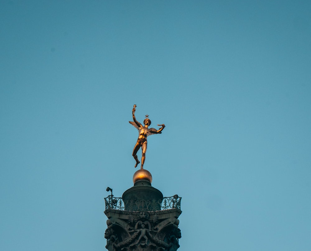 Estatua negra y dorada bajo el cielo azul