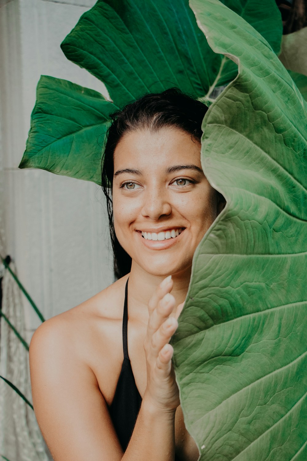 woman in black spaghetti strap top smiling