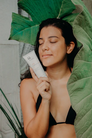 Uma mulher serena desfrutando de uma rotina de cuidados naturais com a pele ao ar livre