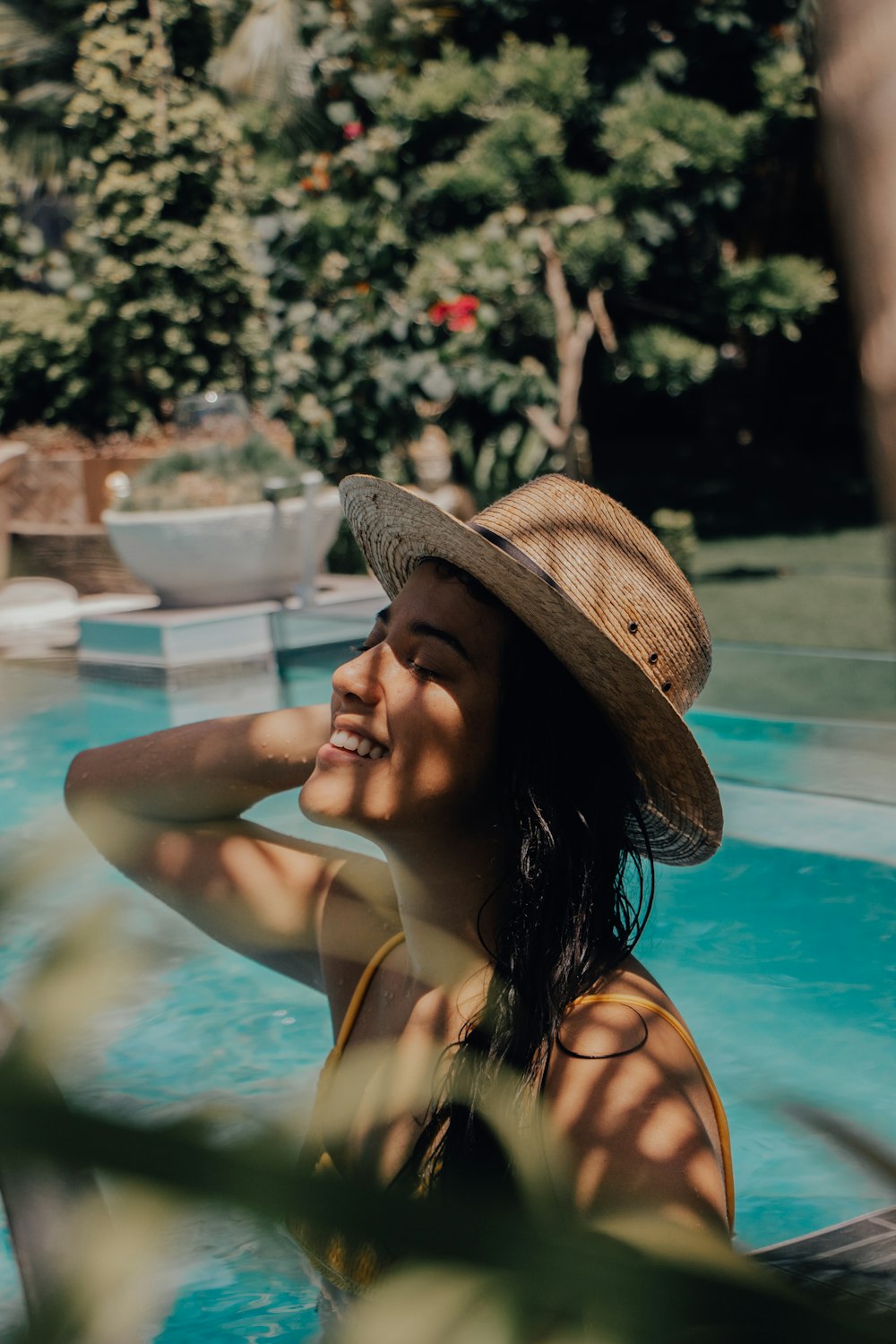 woman in brown sun hat in swimming pool during daytime