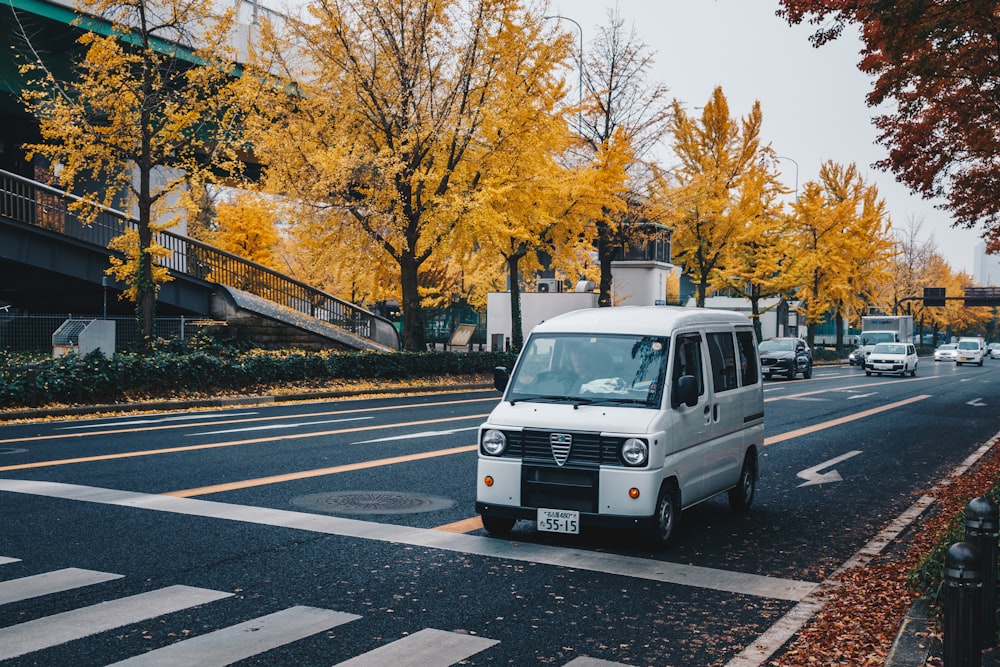 white van on road near trees during daytime