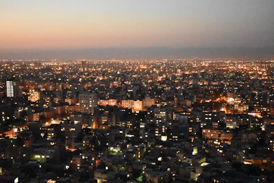 A vibrant cityscape glowing with lights under a twilight sky.