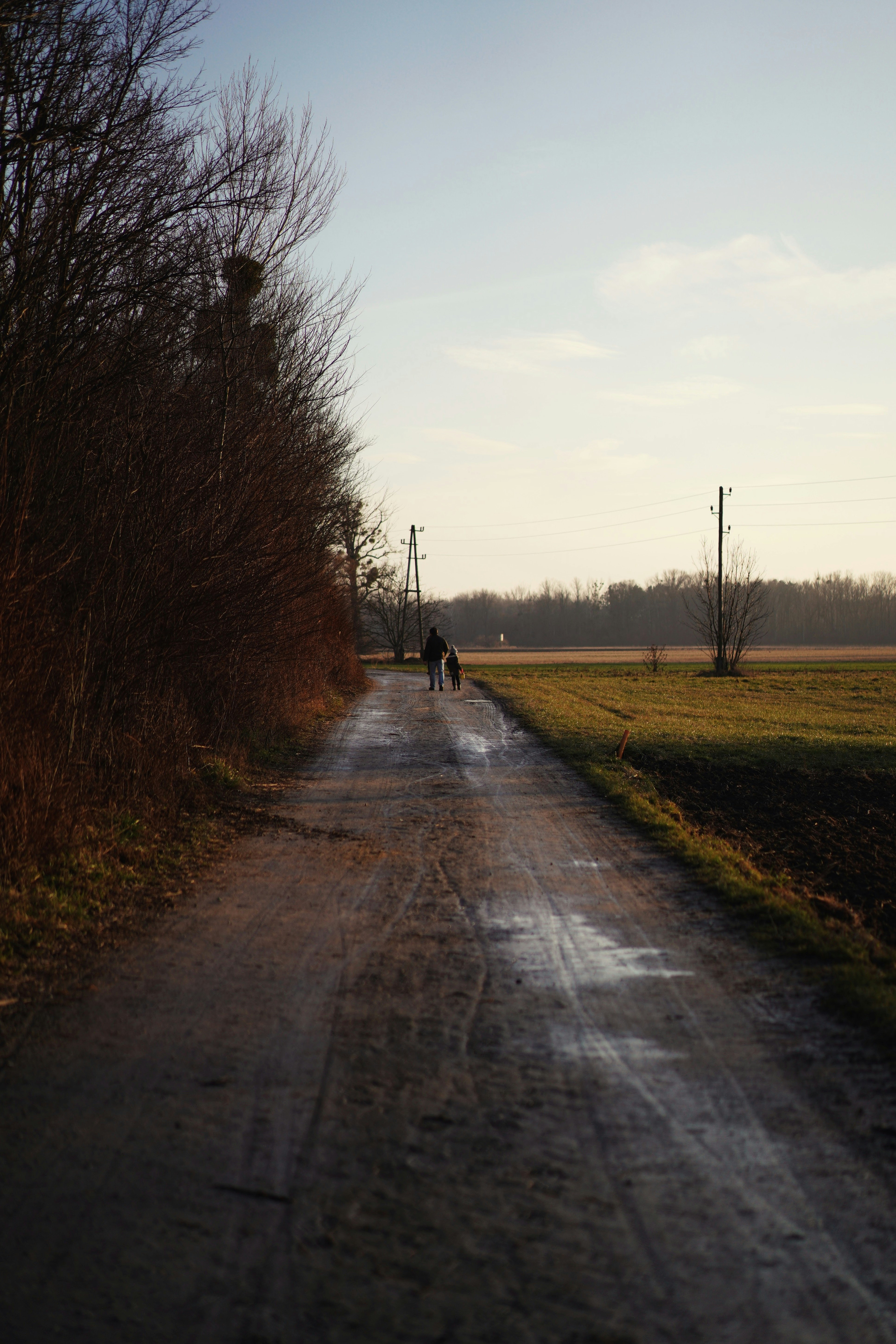 person in black jacket walking on gray concrete road during daytime