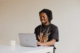 man in black crew neck t-shirt using macbook
