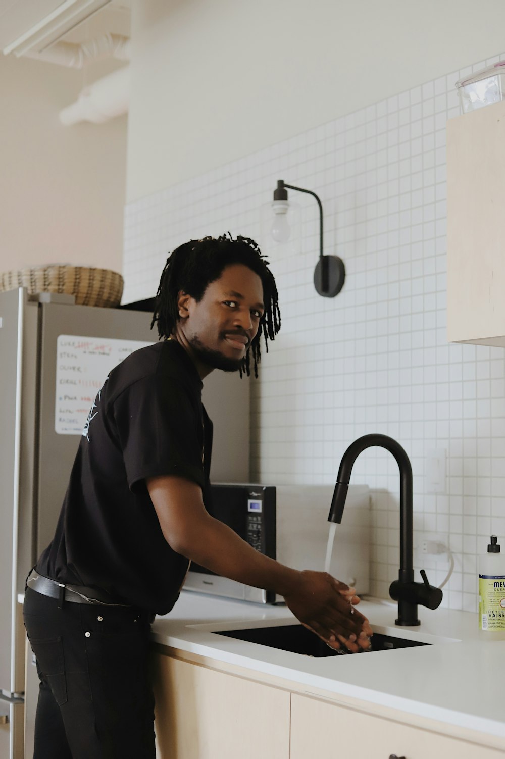 woman in black t-shirt standing in front of sink