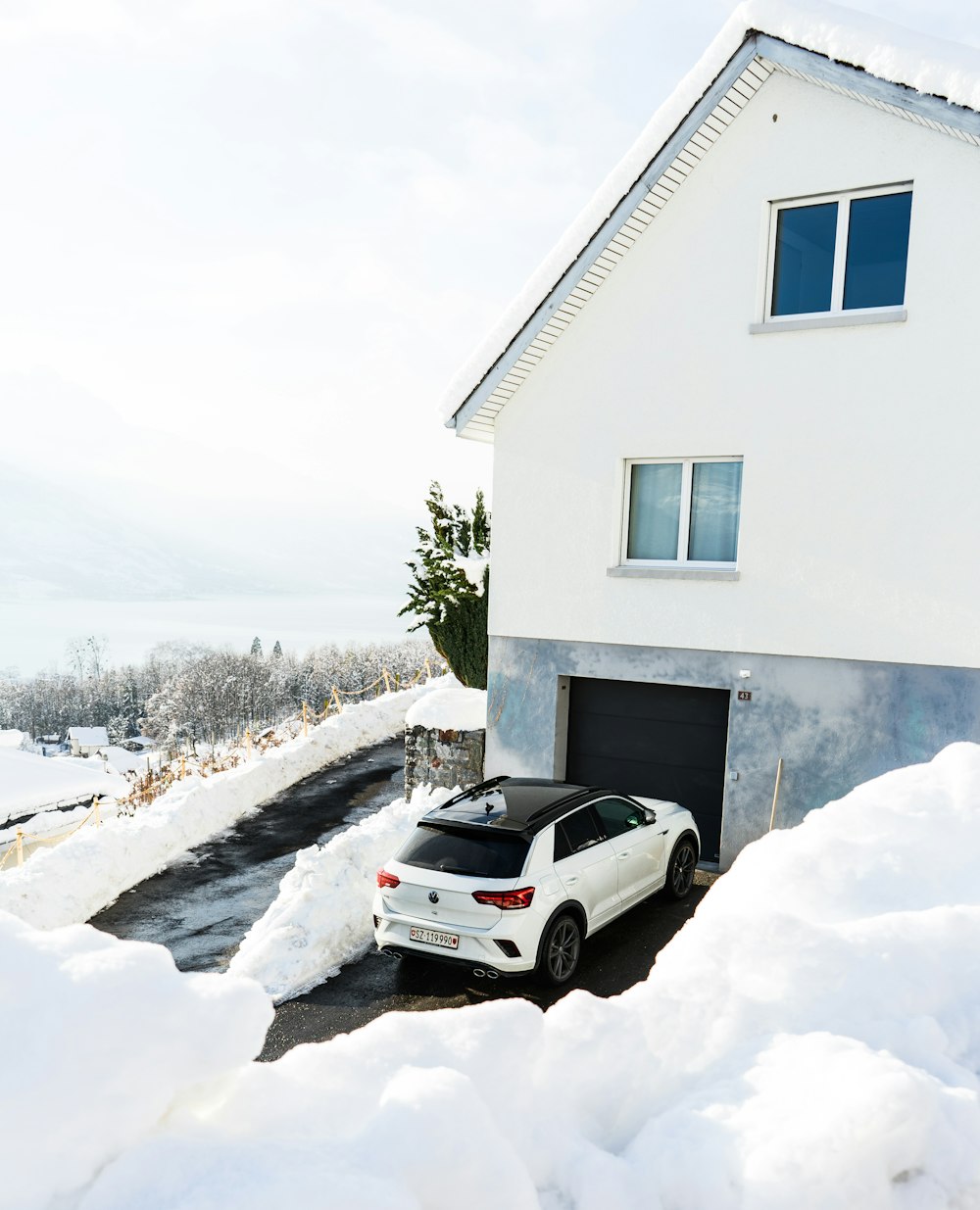 white car parked beside white concrete house during daytime