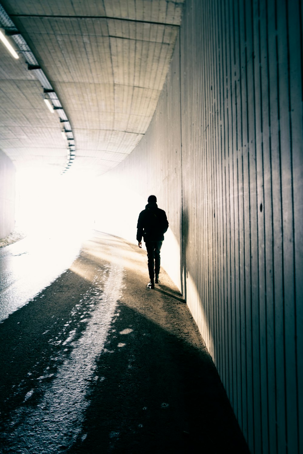 silhouette of person walking on tunnel