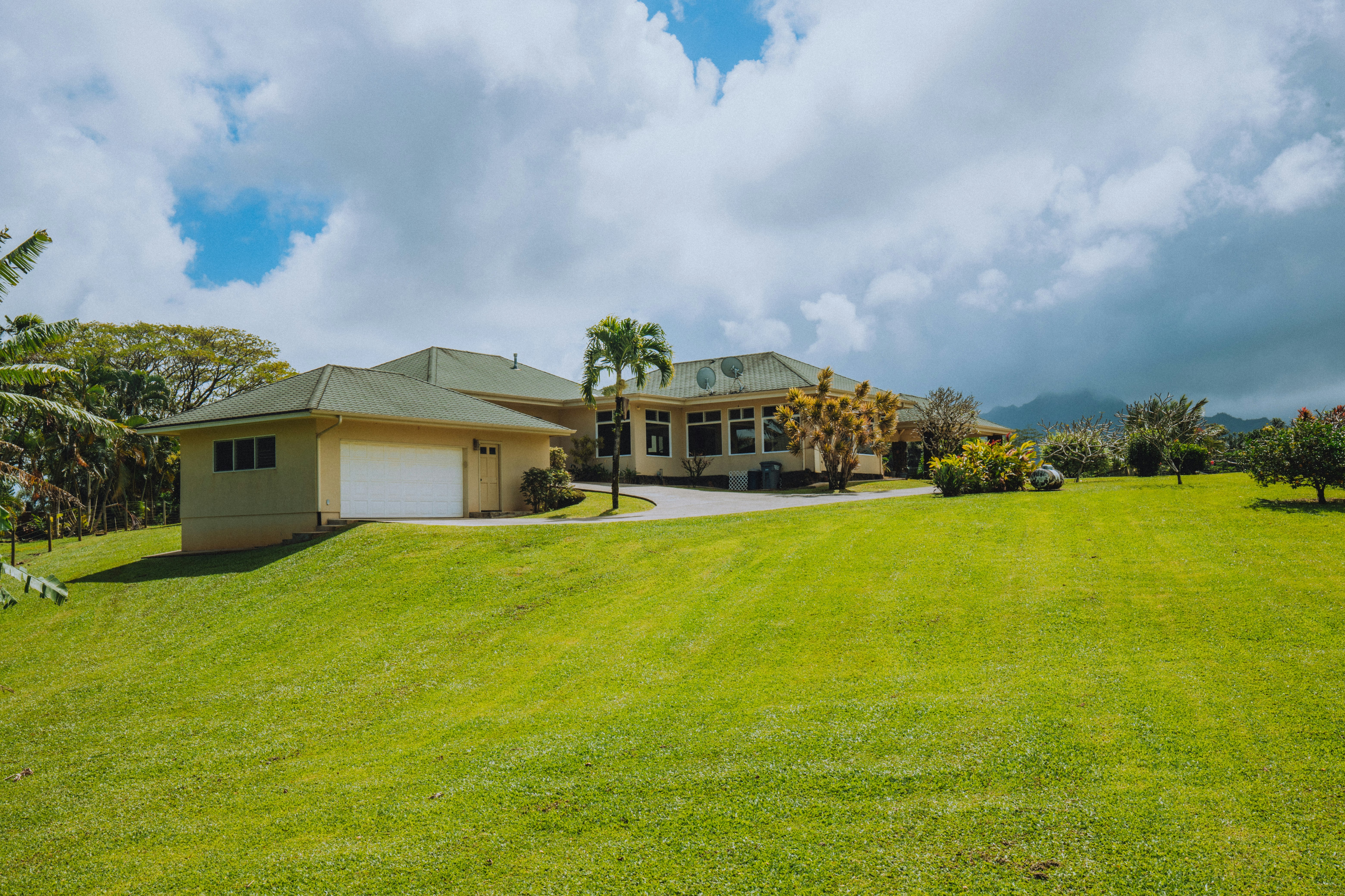 white and brown house on green grass field under blue sky during daytime